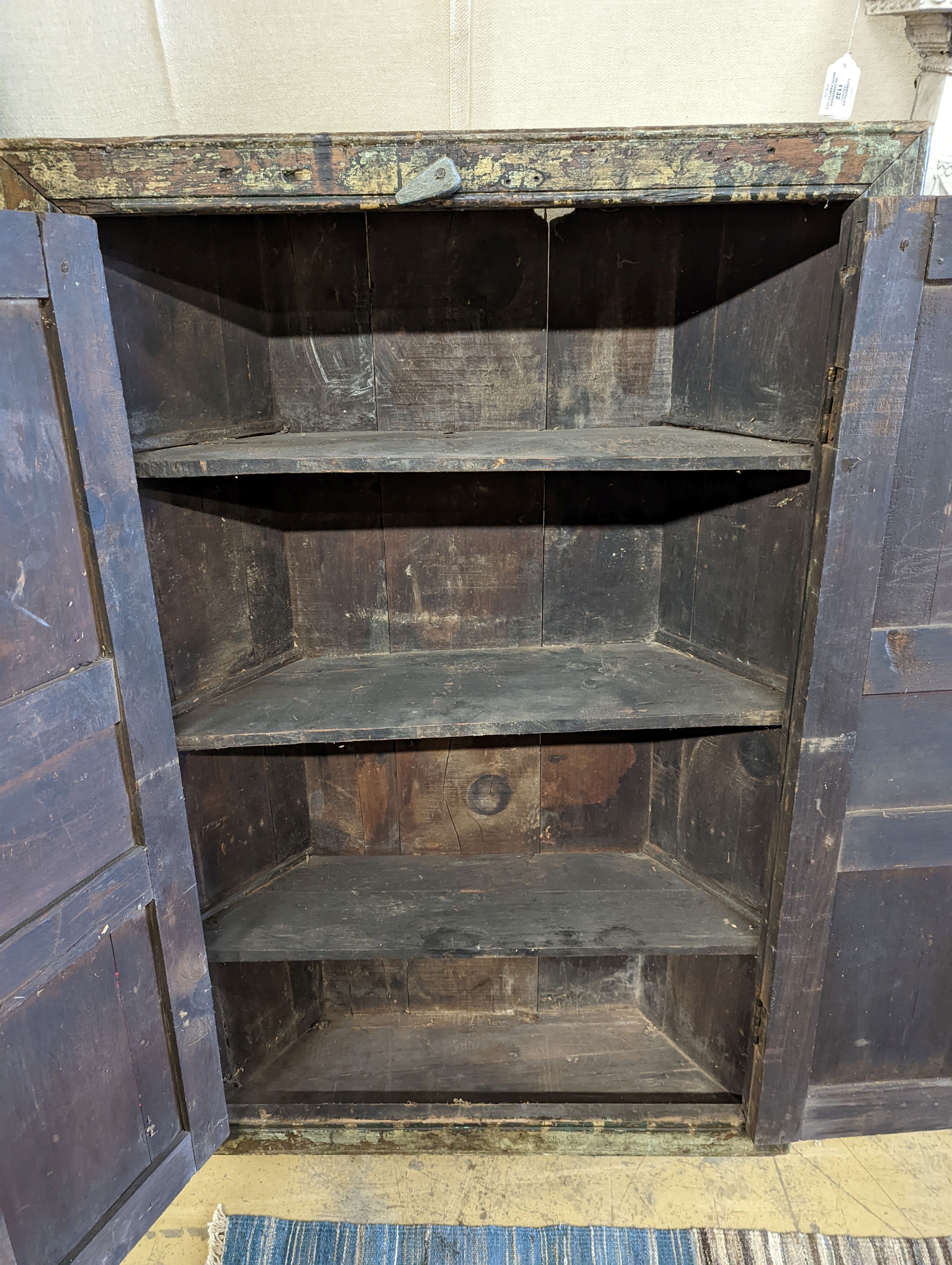 An Afghan painted carved hardwood corner cupboard, width 90cm, height 131cm